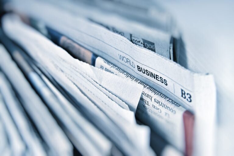a stack of newspapers indicating different publications